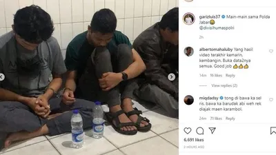 Ferdian Paleka (kiri), YouTuber  terlihat tertunduk saat dimintai keterangan polisi dengan tangan terborgol.[Instagram/garizluis37]