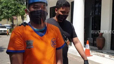 Gilang Aprilian Nugraha (22) yang membungkus korbannya dengan kain jarik berkedok tugas penelitian dan riset saat diarak menuju tahanan Mapolrestabes Surabaya, Sabtu (8/8/2020). [Suara.com/Arry Saputra]