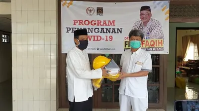 Anggota DPR, Abdul Fikri Faqih menyerahkan alat pelindung diri (APD) yang diterima secara simbolis oleh Direktur RSUD dr. Soeselo Slawi,  dr. Guntur Muhammad Taqwin.