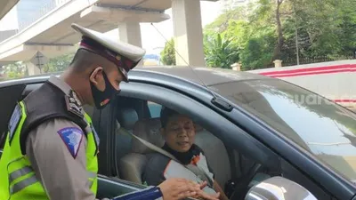 Puluhan kendaraan roda empat di Jalan Gatot Soebroto Simpang Pancoran, Jakarta Selatan, diberhentikan aparat kepolisian karena kedapatan melanggar. (Suara.com/Bagaskara)