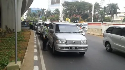 Petugas kepolisian melakukan operasi ganjil-genap di kawasan Pancoran, Jakarta Selatan, Rabu (1/7/2020). Hingga siang hari, telah lebih dari 200 surat tilang dikeluarkan.  Foto: Republika/Bayu Adji P
