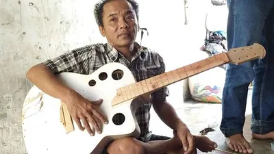 Yono Mulyono menunjukkan salah satu karya kerajinan gitarnya. (Ayotasik.com/Dede Nurhasanudin)