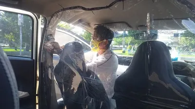 Pengemudi GrabCar tengah memasang pelindung plastik untuk mencegah dan melindungi penumpang dari virus korona, Rabu (29/4/2020).(Ayotegal.com/Lilisnawati)