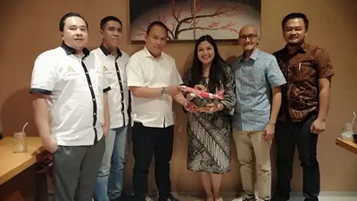 Direktur Utama Ayo Media Network Hilman Hidayat (Ketiga kiri) menerima cendera mata dari Group Head Communication AirAsia Audrey Progastama Petriny di salah satu rumah makan di Kota Bandung, Senin (15/7/2019).