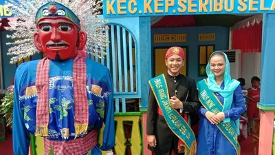 Finalis abang dan nona Kepulauan Seribu berfoto bersama ondel-ondel yang mengenakan pakaian batik bermotif Jembatan Cinta dan daun sukun dalam acara Lebaran Betawi di Monumen Nasional, Jakarta Pusat, Sabtu (20/7/2019). (ANTARA/Sugiharto Purnama)