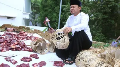 Wali Kota Bogor Bima Arya membungkus daging kurban menggunakan bongsang. (ayobogor.com)