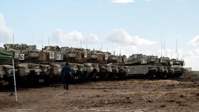 Seorang tentara Israel berjalan mendekati barisan tank Isreal yang menduduki Dataran Tinggi Golan (Reuters)