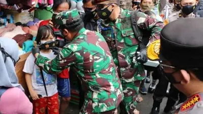 Panglima TNI Marsekal Hadi Tjahjanto memasangkan masker kepada salah satu anak kecil di Pasar Jatinegara/dok: timur.jakarta.go.id