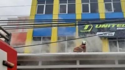 Petugas damkar tengah berusaha memadakam api yang membakar toko sepeda di Kecamatan Curug, Kabupaten Tangerang, Rabu (10/2/2021) pagi. [Foto: Bantennews.co.id]