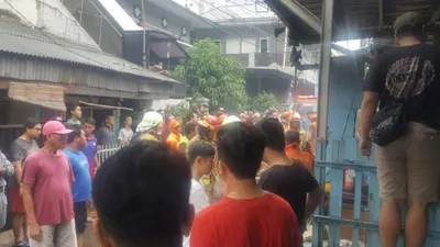 Warga tengah membantu petugas memadamkan kebakaran rumah warga yang berada di belakang Kuningan City (TMC Polda Metro Jaya)