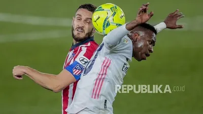 Gelandang Atletico Madrid Koke (kiri) berduel bola dengan winger Real Madrid Vinicius Junior dalam pertandingan derby Madrid di La Liga Spanyol, Minggu (13/12/2020) dini hari WIB.  Foto: AP Photo/Bernat Armangue