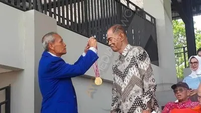 Plt. Ketum PAMI Merari Nainggolan mengalungkan medali kepada Koptu Marinir (Purn) Soetiyo/Ayojakarta.com