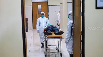 Petugas kesehatan dengan menggunakan APD menangani pasien yang diduga terindikasi virus corona saat simulasi penanganan pasien yang terdeteksi virus corona di RS Margono Soekarjo Purwokerto, Senin (3/1/2020). (Suara.com/Anang Firmansyah)
