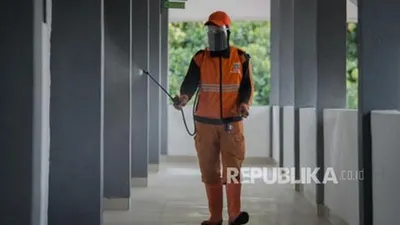 Petugas PPSU Kelurahan Palmerah menyemprotkan cairan disinfektan di lingkungan Madrasah Aliyah Negeri 22 Jakarta, Palmerah, Jakarta, Jumat (4/12). Penyemprotan tersebut dilakukan akibat sebanyak 21 guru dan 9 staf Tata Usaha (TU) di MAN 22 Jakarta terkonfirmasi positif Covid-19 usai melakukan perjalanan ke Yogyakarta. Republika/Thoudy Badai