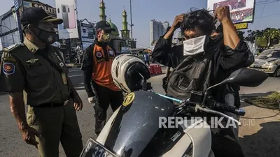 Petugas menghimbau pengendara untuk memakai masker saat Sosialisasi Gerakan Bermasker di Jalan Raya Margonda, Depok, Jawa Barat, Senin (20/7). Pemerintah Kota Depok melakukan Sosialisasi Gerakan Bermasker menjelang penerapan sanksi denda sebesar Rp 50.000 bagi warga yang tidak menggunakan masker, yang akan diberlakukan mulai Kamis (23/7). (Republika/Putra M. Akbar)