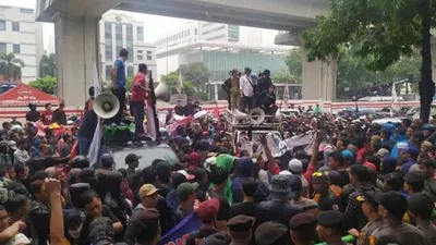 Warga Tanjung Priok yang menggelar aksi di depan Kemenkumham masih bertahan meski hujan mengguyur kawasan Kuningan Jakarta Selatan pada Rabu (22/1/2020). (Suara.com/Stephanus Aranditio)