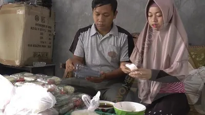 Muhamad Khoirul Daru dan istrinya mengemas mi keriting dan sayuran dalam satu wadah untuk dijual ke pembeli. Khoirul berinovasi membuat mie ayam mentah setelah di-PHK dari perusahaannya akibat dampak korona. (Ayosemarang.com/Edi Prayitno)