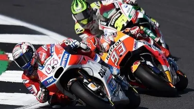 Pembalap Ducati, Andrea Dovizioso, berada di depan rivalnya Marc Marquez (Repsol Honda) dan Cal Crutchlow (LCR Honda) pada balapan MotoGP Inggris 2017 di Sirkuit Silverstone, Minggu (27/8). [AFP/Oli Scarff]