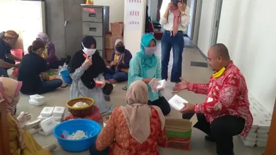 Warga tengah menyiapkan nasi boks untuk dibagikan ke masyarakat terdampak Covid-19 di Bogor. (Ayobogor/Husnul Khatimah)