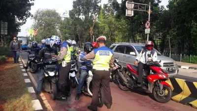 Para pengendara yang masuk ke jalur Transjakarta di Jalan Sutoyo, Jakarta Timur, Kamis (23/7), ditilang petugas polisi dalam Operasi Patuh Jaya 2020. (Foto: Meiliza Laveda)