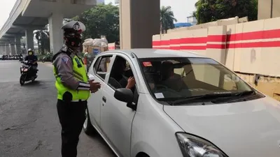 ilustrasi. Petugas memberentikan pengendara mobil yang melanggar ganjil genap di satu titik ruas jalan penerapan gage yakni di Jalan Gatot Soebroto, Simpang Pancoran, Jakarta Selatan. (Suara.com/Bagaskara)