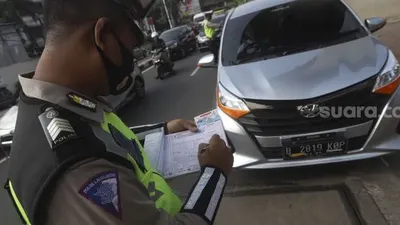 Anggota kepolisian memberikan sanksi tilang kepada pengendara mobil yang melanggar aturan ganjil genap di kawasan Fatmawati, Jakarta, Senin (10/8/2020). [Suara.com/Angga Budhiyanto]