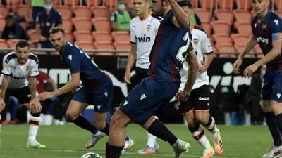 Pemain Levante, Gonzalo Melero, saat mengeksekusi penalti ke gawang Valencia, Sabtu (13/6/2020). (Jose Jordan/AFP).