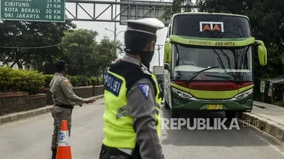 Polisi menghentikan bus saat penerapan pelarangan mudik di Jalur Pantura, Perbatasan Kabupaten Bekasi dengan Karawang, Kabupaten Bekasi, Jawa Barat, Sabtu (25/4/2020). Hari kedua penerapan pelarangan mudik di jalur pantura masih banyak pengendara yang memaksakan untuk mudik dan tidak menerapkan jarak sosial. Foto: Republika/Putra M. Akbar