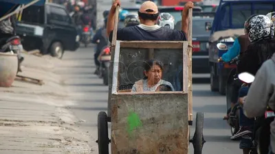 Seorang lelaki dari keluarga miskin mengangkut anak dan istrinya dengan gerobak. ilustrasi (foto: Raisan Al Farisi/ Republika)