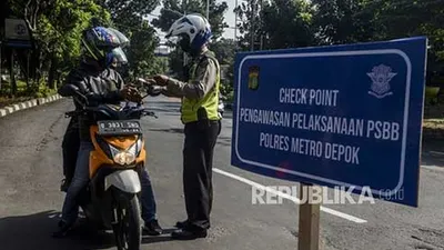 Polisi memeriksa identitas pengendara motor berboncengan yang akan menuju Jalan Raya Margonda saat hari pertama pemberlakukan Pembatasan Sosial Berskala Besar (PSBB) di perbatasan Jakarta dan Depok, Lenteng Agung, Jakarta, Rabu (15/4/2020). (Foto: Republika/Putra M Akbar)
