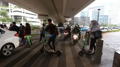 Pengguna skuter listrik melintas di kawasan Jalan Jenderal Sudirman, Jakarta Pusat. (Warta Kota/Angga Bhagya Nugraha)