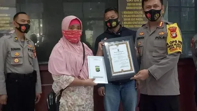 Kepala Polres Metro Bekasi, Kombes Hendra Gunawan beri penghargaan kepada ojol perempuan, Dwi Wulan Meilani.  Foto: Dok