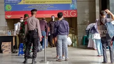 Petugas gabungan dari TNI dan Polri saat memeriksa suhu tubuh pengunjung di Pasar Tanah Abang. (Suara.com/Arga).