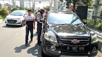 Petugas Dishub Surakarta memeriksa pengendara berpelat luar kota di Tugu Makutha, batas wilayah Kota Solo. (dok Dishub Surakarta).