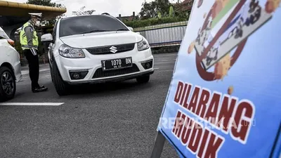 Petugas kepolisian mengarahkan kendaraan untuk memutar balik di pos pemeriksaan Pembatasan Sosial Berskala Besar (PSBB) di Gerbang Tol Cileunyi, Kabupaten Bandung, Selasa (28/4). Penindakan berupa pemeriksaan surat kendaraan, surat tugas serta mengarahkan kendaraan untuk memutar balik tersebut merupakan tidak lanjut kebijakan larangan penggunaan kendaraan umum dan kendaraan bermotor pribadi untuk mudik (FOTO : ABDAN SYAKURA/REPUBLIKA)