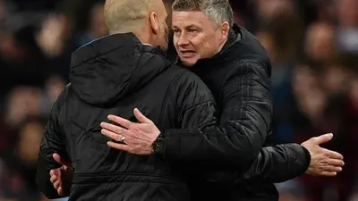 Manajer Manchester City, Pep Guardiola (kiri) bercengkerama dengan manajer Manchester United, Ole Gunnar Solskjaer pada laga leg kedua semifinal Piala Liga Inggris 2019/2020 di Etihad Stadium, Kamis (30/1/2020) dini hari WIB. [AFP]
