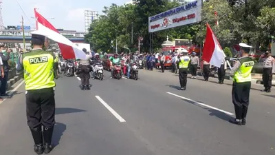 Peringati HUT Kemerdekaan RI ke-75 cukup mengharukan dilaksanakan aparat Polres Metro (Polrestro) Depok bersama pengendara kendaraan di setiap persimpangan di Jalan Margonda Raya, Kota Depok, Senin (17/8). Foto: Republika/Rusdy Nurdiansyah
