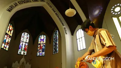Seorang petugas membersihkan kursi menggunakan cairan desinfektan di Gereja Katedral Santo Petrus, Jalan Merdeka, Kota Bandung, Jumat (12/6/2020).  (Ayobandung.com/Irfan Al-Faritsi)