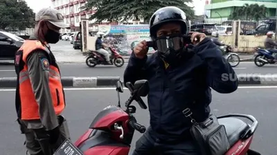 Petugas Satpol PP melarang pengendara melinta asrama STT Bethel Petamburan. (Suara.com/Bagaskara).