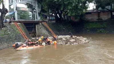 Petugas membersihkan sampah yang tersangkut di Pintu Air Manggarai (Kumparan/Amanaturrosyidah)
