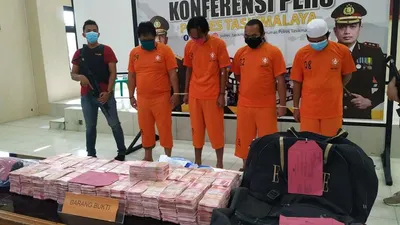 Polisi menunjukan barang bukti uang palsu saat konferensi pers pengungkapan kasus peredaran uang palsu di Polres Tasikmalaya, Rabu, (13/5). Dalam kasus itu, polisi mengamankan barang bukti sebanyak 29.600 lembar uang palsu pecahan Rp100 ribu. (Foto: Bayu Adji P. / Republika)
