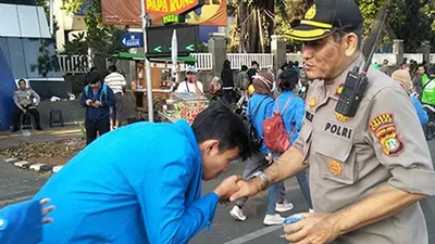 Kepala Pengamanan Objek Jalan Gerbang Pemuda, Kompol Agus Widar saat dicium tangannya oleh para mahasiswa yang hendak menuju gedung DPR/MPR, Senayan, Jakarta, Senin (30/9/2019)/Ayojakarta.com