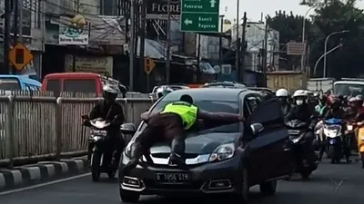 Polisi Kembali Menclok di Kap Mobil, Begini Kronologinya