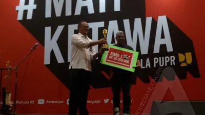 Reinold Lawalata menerima hadiah usai menjuarai Stand Up Competition Mati Ketawa Ala PUPR (Ayojakarta.com/Lopi Kasim)