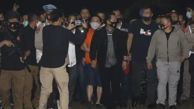 Petugas kepolisian membawa buronan kasus korupsi pengalihan hak tagih (cessie) Bank Bali Joko Soegiarto Tjandra alias Djoko Tjandra yang ditangkap di Malaysia setibanya di Bandara Halim Perdanakusuma, Jakarta, Kamis (30/7/2020). (Suara.com/Angga Budhiyanto)