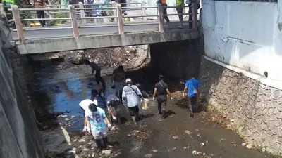 Sejumlah warga yang terjaring operasi yustisi masker membersihkan sungai selama 15 menit di Kota Solo, Senin (14/9/2020). (ist)