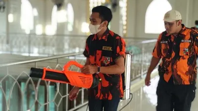 Satuan Siswa, Pelajar dan Mahasiswa Pemuda Pancasila (Sapma PP) Jakarta Timur bergotong royong menyemprot cairan disinfektan ke masjid