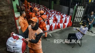 Sejumlah petugas saat mendistribusikan Bantuan Sosial (Bansos) Presiden di kawasan Kebon Jeruk, Jakarta. Kementerian Sosial telah menyalurkan anggaran bansos sembako untuk masyarakat di Jabodetabek selama pandemi Covid sebesar Rp 5,65 triliun atau 82,59 persen.  (Foto: republika/Putra M. Akbar)