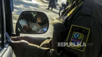 Petugas Satpol PP saat memeriksa dokumen pengendara yang akan memasuki wilayah DKI Jakarta. (Foto: Republika/Putra M. Akbar)