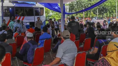 Warga menunggu proses perpanjangan SIM di Pelayanan SIM Keliling Masjid At-Tin, Jakarta Timur, Kamis (4/6). [Suara.com/Alfian Winanto]